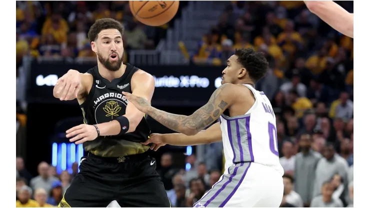 Klay Thompson #11 of the Golden State Warriors passes around Malik Monk #0 of the Sacramento Kings