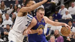 Nikola Jokic #15 of the Denver Nuggets drives around Rudy Gobert #27 of the Minnesota Timberwolves