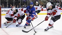 Chris Kreider #20 of the New York Rangers and Nathan Bastian #14 of the New Jersey Devils battle for the puck
