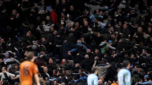 Manchester City fans turn their back on the pitch following a goal.