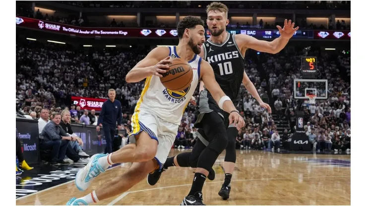 Klay Thompson #11 of the Golden State Warriors drives to the basket as Domantas Sabonis #10 of the Sacramento Kings defends