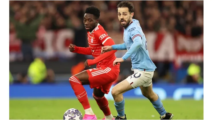Alphonso Davies of FC Bayern Munich battles for possession with Bernardo Silva of Manchester City