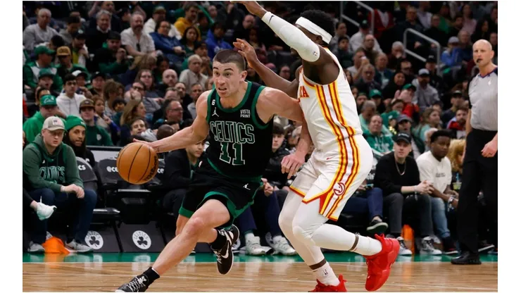 Payton Pritchard #11 of the Boston Celtics dribbles the ball around Aaron Holiday #3 of the Atlanta Hawks