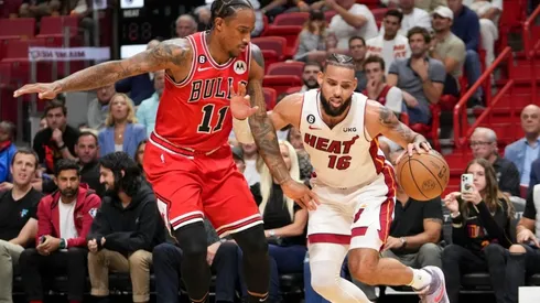 Caleb Martin #16 of the Miami Heat drives past DeMar DeRozan #11 of the Chicago Bulls.