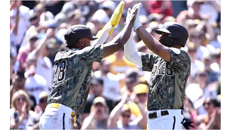 Xander Bogaerts #2 of the San Diego Padres (R) is congratulated by teammate Jose Azocar #28