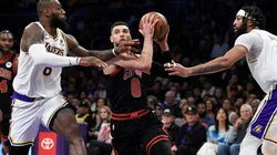 Zach LaVine #8 of the Chicago Bulls drives to the basket in between LeBron James #6 and Anthony Davis #3 of the Los Angeles Lakers