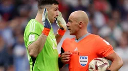 Emiliano Martinez of Argentina and referee Szymon Marciniak