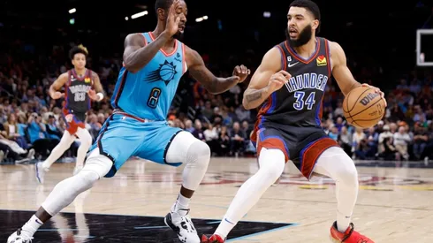 Kenrich Williams #34 of the Oklahoma City Thunder handles the ball against Terrence Ross #8 of the Phoenix Suns
