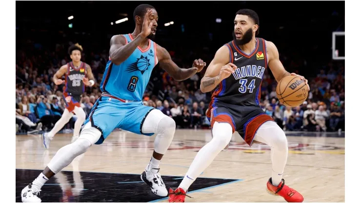 Kenrich Williams #34 of the Oklahoma City Thunder handles the ball against Terrence Ross #8 of the Phoenix Suns