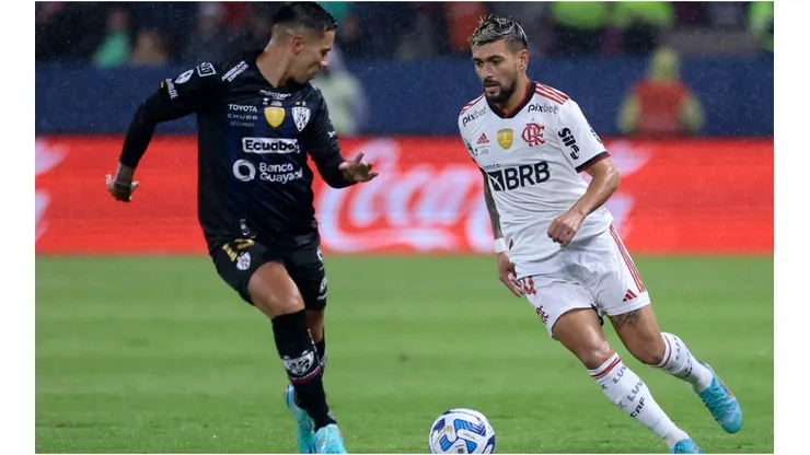 Giorgian de Arrascaeta of Flamengo (R) competes for the ball with Matias Fernandez of Independiente del Valle