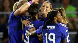 The USWNT players celebrate after scoring a goal