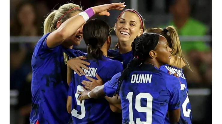 The USWNT players celebrate after scoring a goal
