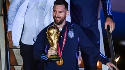 Lionel Messi holding the FIFA World Cup trophy after Argentina's victory in Qatar 2022.