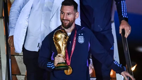 Lionel Messi holding the FIFA World Cup trophy after Argentina's victory in Qatar 2022.