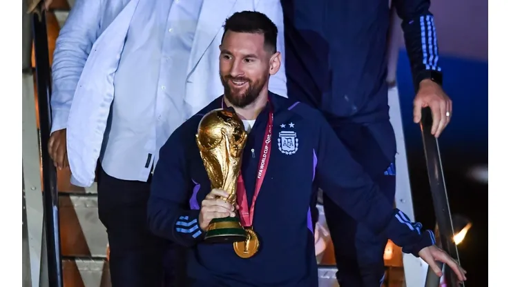 Lionel Messi holding the FIFA World Cup trophy after Argentina's victory in Qatar 2022.