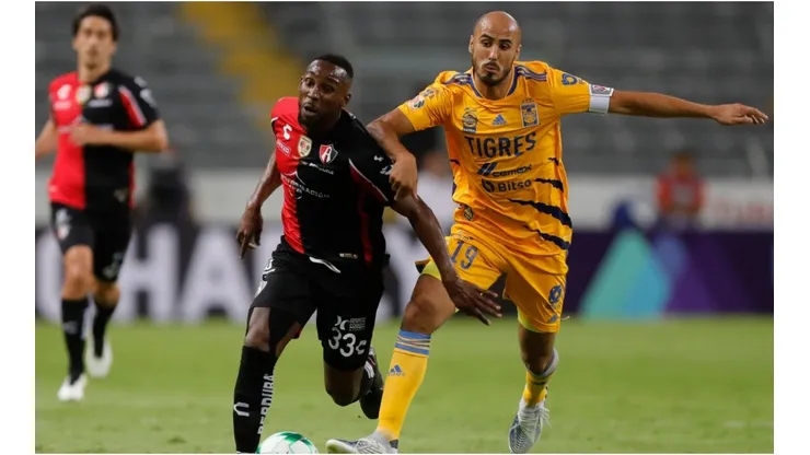 Julian Quiñones of Atlas fights for the ball with Guido Pizarro of Tigres