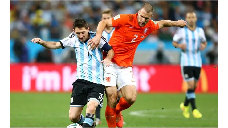 Lionel Messi of Argentina is challenged by Ron Vlaar of the Netherlands during the 2014 FIFA World Cup Brazil Semi Final
