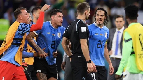 Uruguay players argue with referee Daniel Siebert.