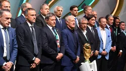 Managers of the national teams at Qatar 2022 pose with the FIFA World Cup trophy.