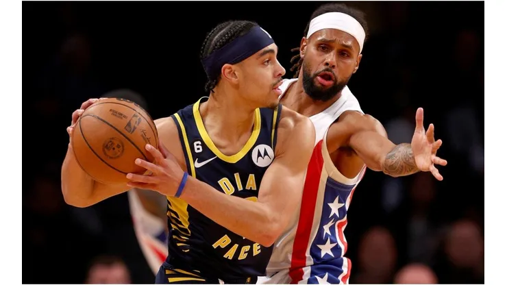Andrew Nembhard of the Indiana Pacers tries to keep the ball from Patty Mills of the Brooklyn Nets