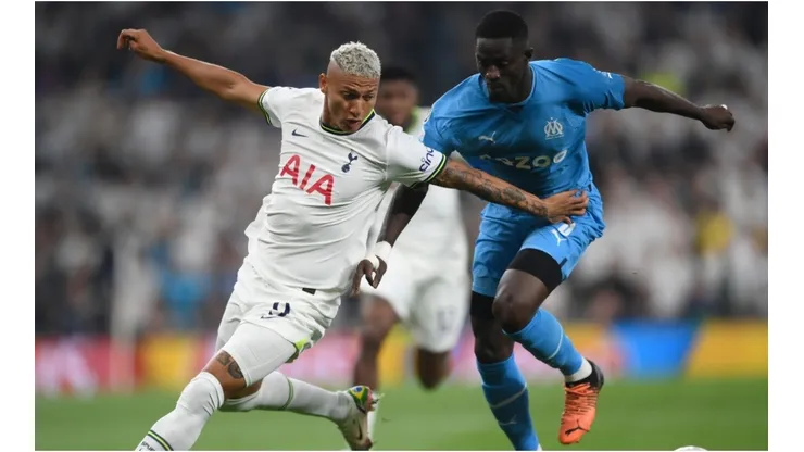 Richarlison of Tottenham Hotspur battles for possession with Eric Bailly of Marseille