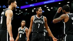 Kevin Durant talks with Ben Simmons and Kyrie Irving of the Brooklyn Nets