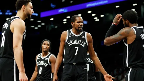 Kevin Durant talks with Ben Simmons and Kyrie Irving of the Brooklyn Nets