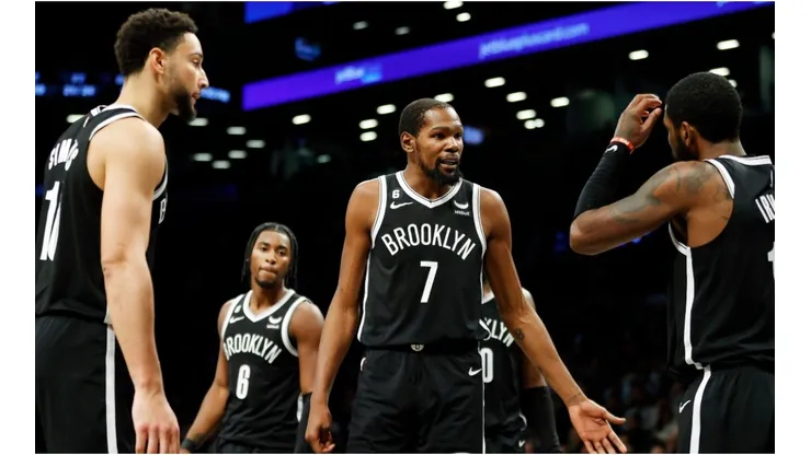 Kevin Durant talks with Ben Simmons and Kyrie Irving of the Brooklyn Nets
