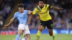 John Stones of Manchester City is challenged by Donyell Malen of Borussia Dortmund