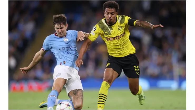 John Stones of Manchester City is challenged by Donyell Malen of Borussia Dortmund