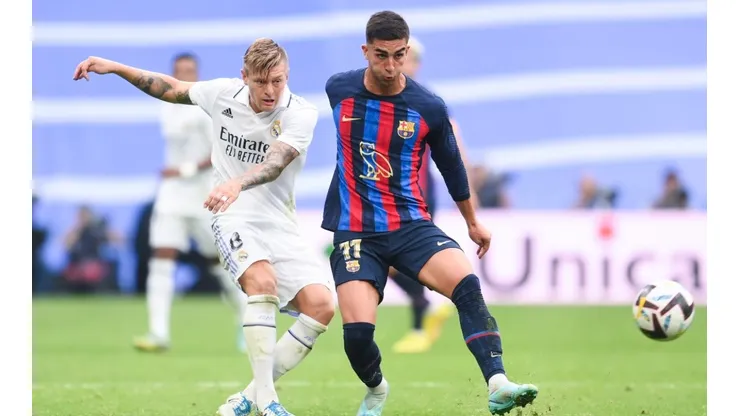 Toni Kroos of Real Madrid CF competes for the ball with Ferran Torres of FC Barcelona