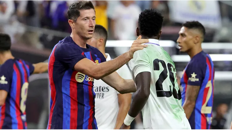 Vinicius of Real Madrid with Robert Lewandowski of Barcelona