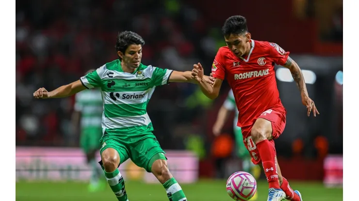 Carlos Orrantia of Santos Laguna fights for the ball with Jorge Rodriguez of Toluca