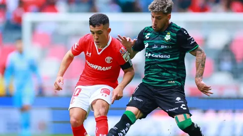 Leonardo Fernandez of Toluca fights for the ball with Fernando Gorriaran of Santos Laguna
