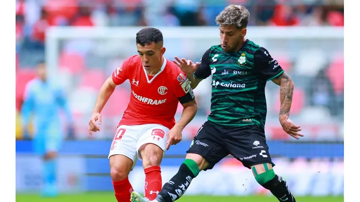 Leonardo Fernandez of Toluca fights for the ball with Fernando Gorriaran of Santos Laguna