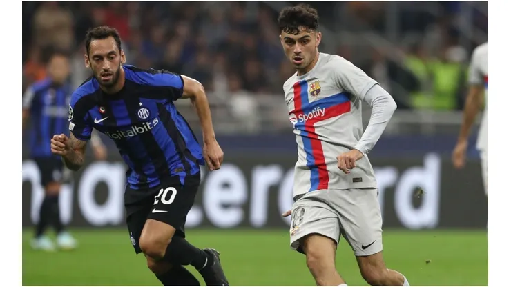 Pedri (R) of FC Barcelona is challenged by Hakan Calhanoglu of FC Internazionale