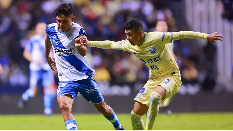 Martin Barragan of Puebla battles for possession with Emilio Lara of America