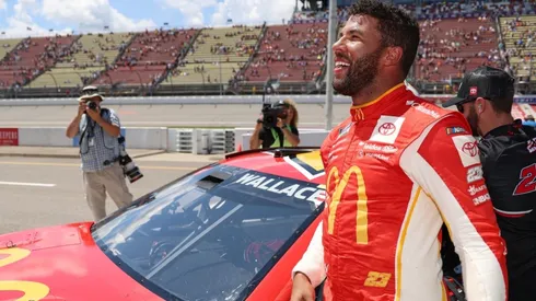 Bubba Wallace celebrates after winning the pole award for the FireKeepers Casino 400