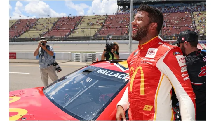 Bubba Wallace celebrates after winning the pole award for the FireKeepers Casino 400