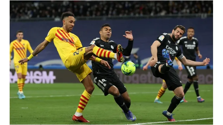 Pierre-Emerick Aubameyang of Barcelona battles for possession with Casemiro of Real Madrid