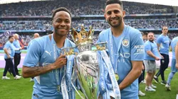 Raheem Sterling and Riyad Mahrez of Manchester City celebrate with the Premier League trophy after their side finished the season as Premier League champions during the Premier League match between Manchester City and Aston Villa at Etihad Stadium on May 22, 2022 in Manchester, England.