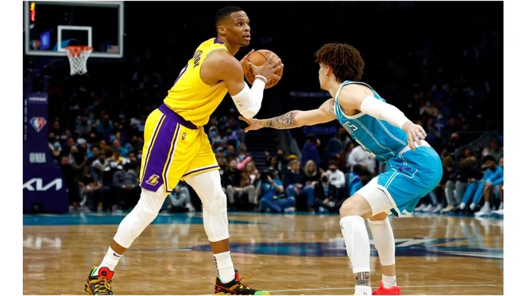 Russell Westbrook of the Los Angeles Lakers looks over the court as he is guarded by LaMelo Ball of the Charlotte Hornets