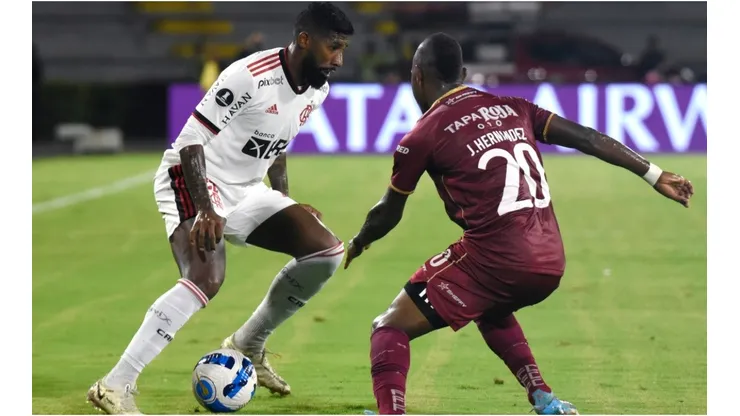 Rodinei of Flamengo fights for the ball Junior Hernández of Deportes Tolima
