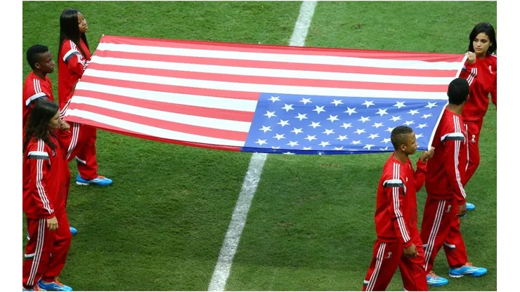 The United States flag is carried onto the field