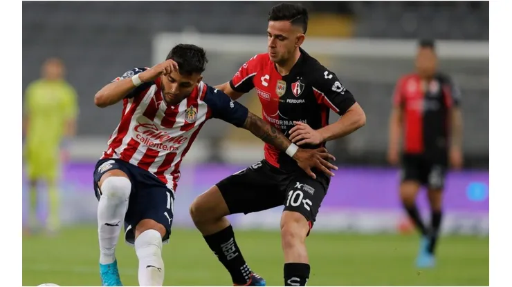 Gonzalo Maroni of Atlas fights for the ball with Alexis Vega of Chivas