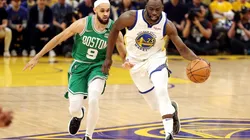 Draymond Green #of the Golden State Warriors dribbles against Derrick White of the Boston Celtics