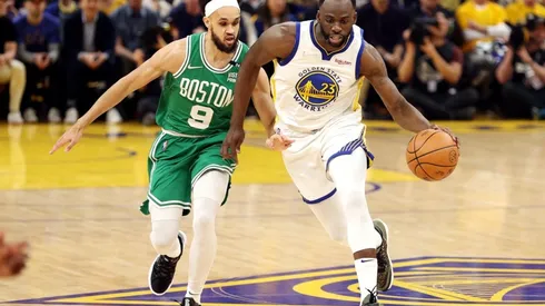 Draymond Green #of the Golden State Warriors dribbles against Derrick White of the Boston Celtics