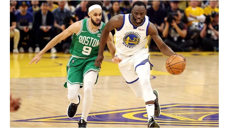 Draymond Green #of the Golden State Warriors dribbles against Derrick White of the Boston Celtics