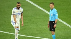 Karim Benzema of Real Madrid and Referee Clement Turpin look on as they wait for the result of a VAR review