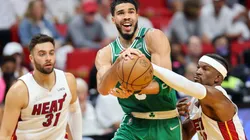 Jayson Tatum of the Boston Celtics drives to the basket against Max Strus and Jimmy Butler of the Miami Heat